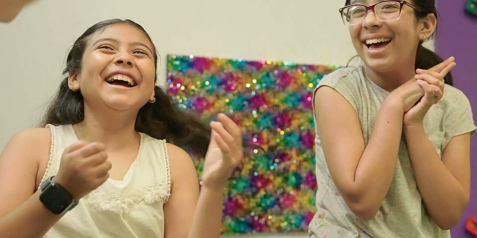 Two girls laughing and clapping