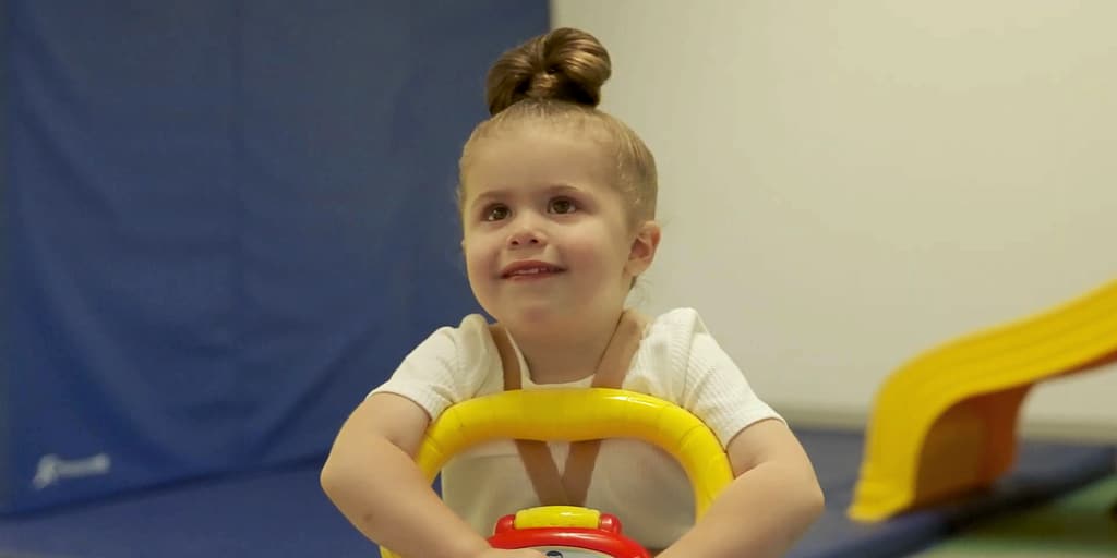A toddler smiling on a ride-on toy