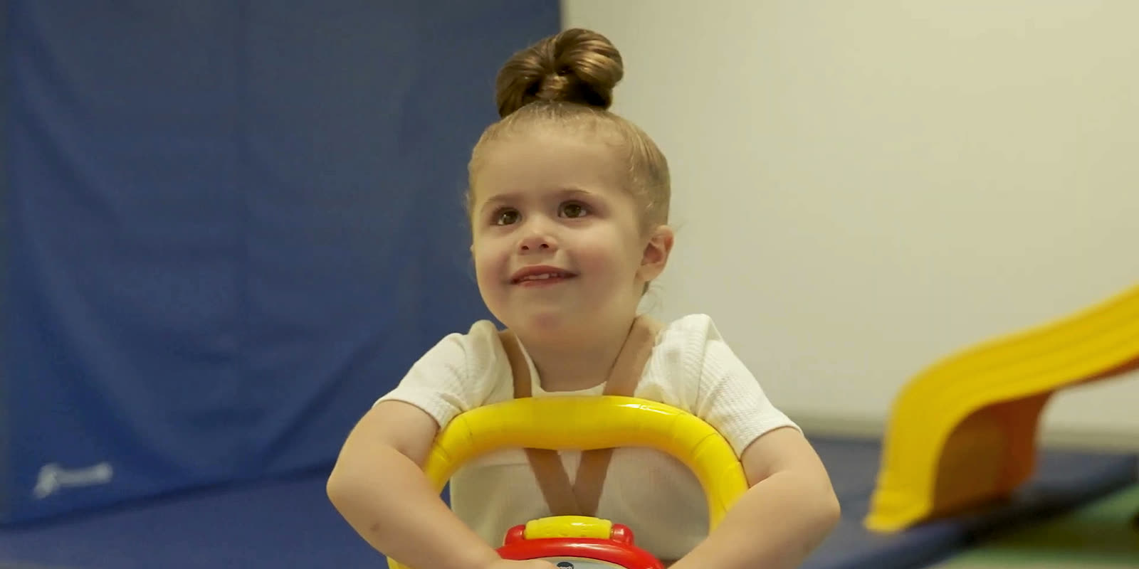 A toddler smiling on a ride-on toy
