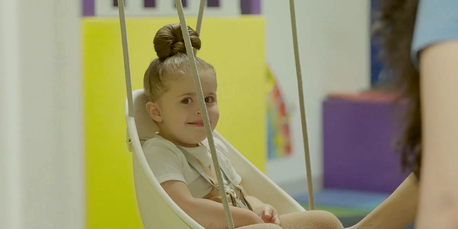 A young girl smiling on a swing